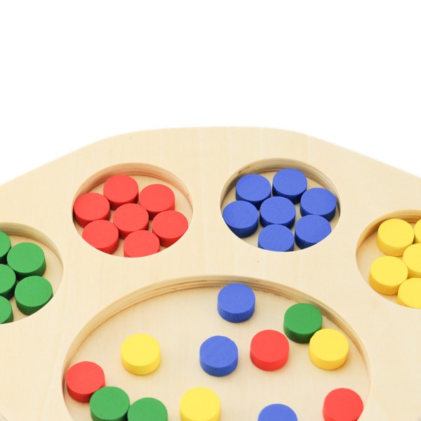 Enfant manipulant des jetons colorés sur un plateau de tri en bois pour développer sa motricité fine