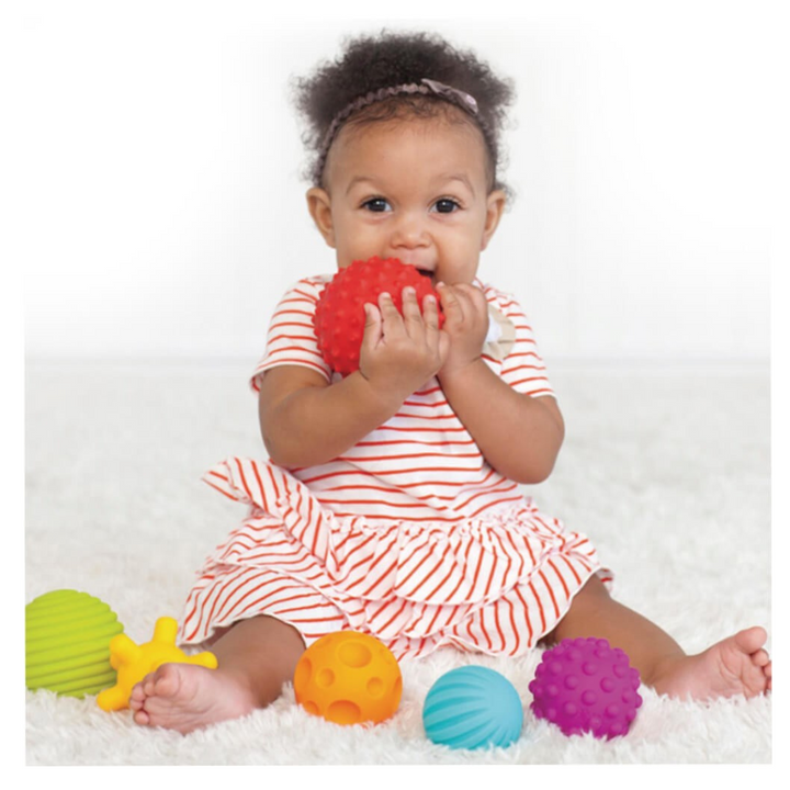 Bébé manipulant une balle sensorielle à picots pour la motricité fine