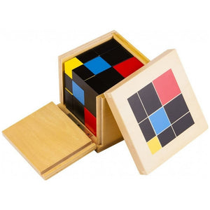 Gros plan sur les pavés et cubes du puzzle Trinôme Montessori : rouge, bleu, jaune, noir