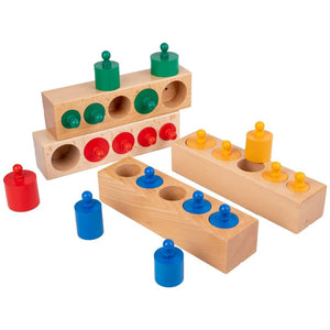 Enfant manipulant les blocs de cylindres Montessori pour apprendre les tailles