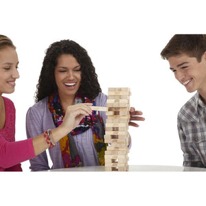Famille riant autour d'une tour Jenga en construction