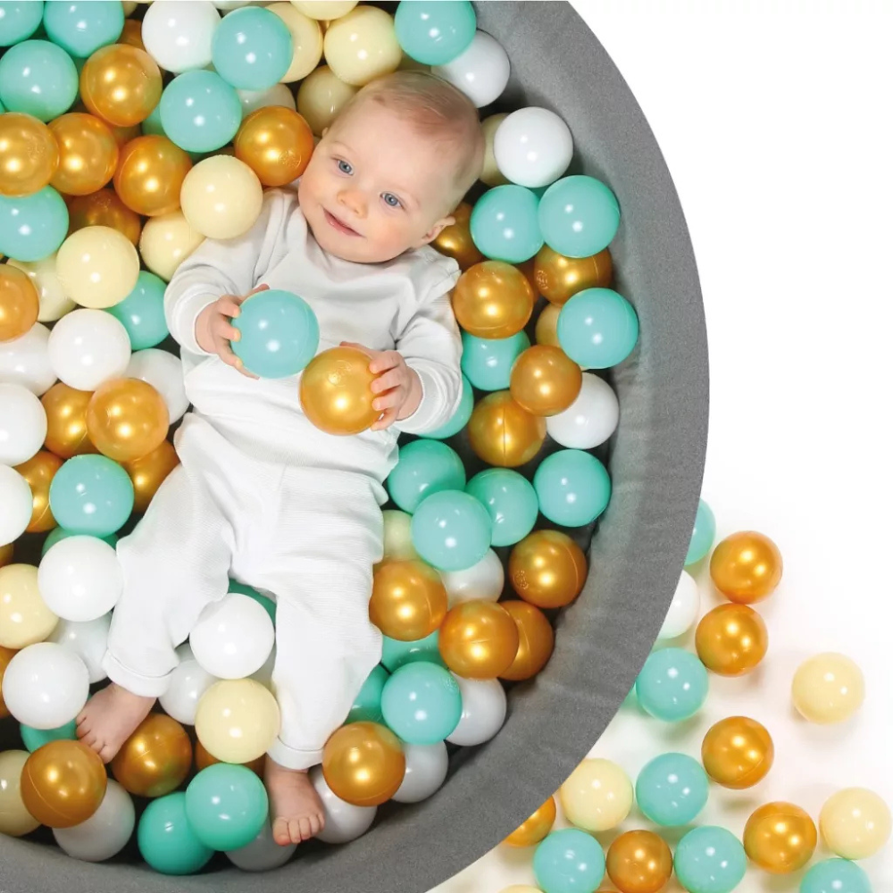 Enfant jouant dans une piscine à balles grise méthode Montessori