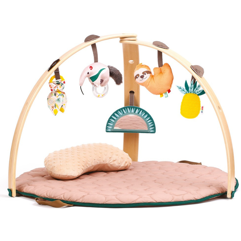 Bébé utilisant le coussin ventral sur le tapis d'éveil Montessori