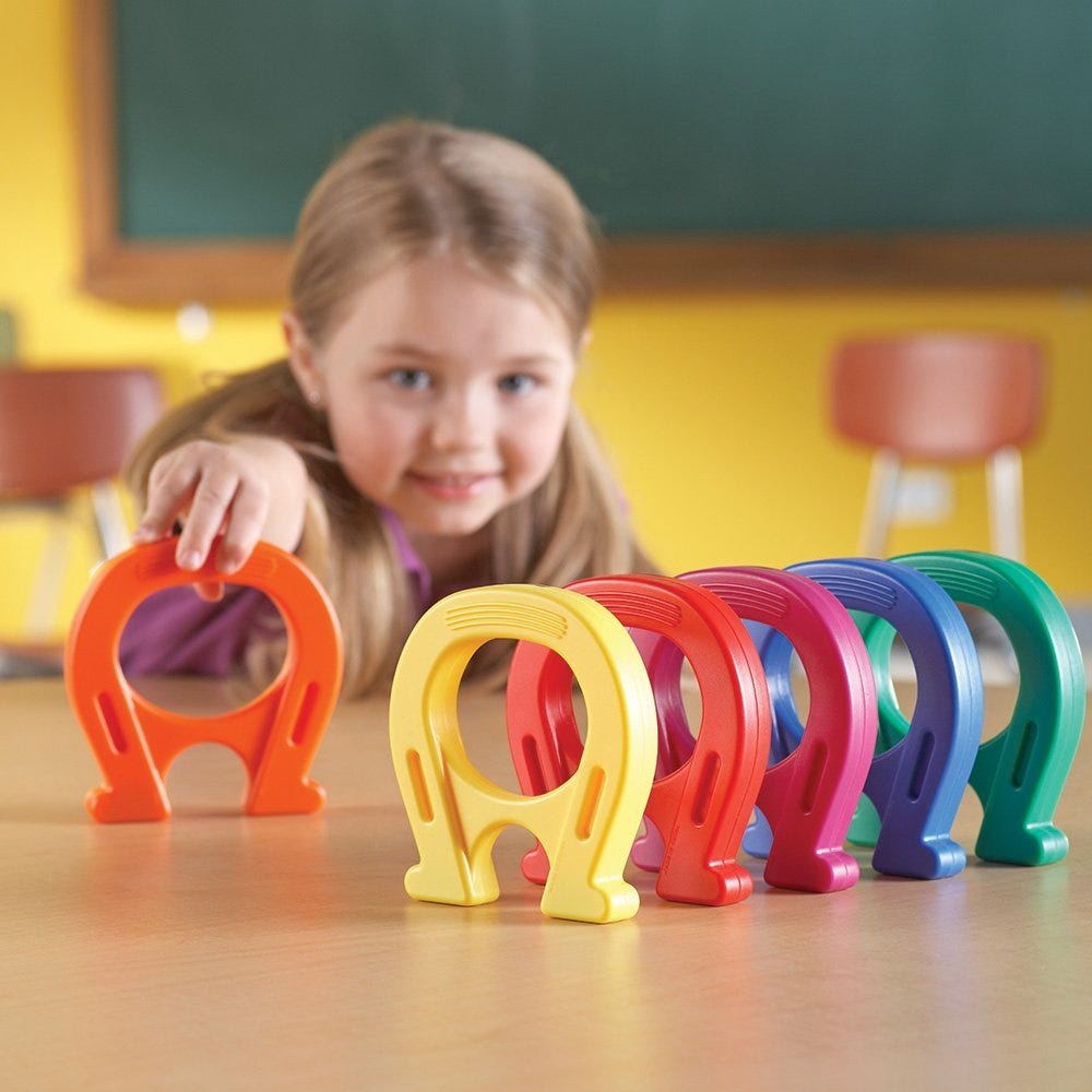 Enfant manipulant un aimant en fer à cheval pour attirer des trombones