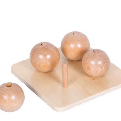 Jeu Montessori avec quatre boules en bois à enfiler sur tiges verticales