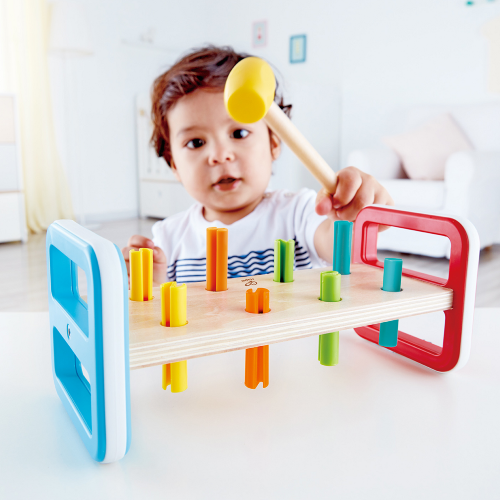 Banc à marteler en bois Hape arc-en-ciel avec maillet et chevilles colorées