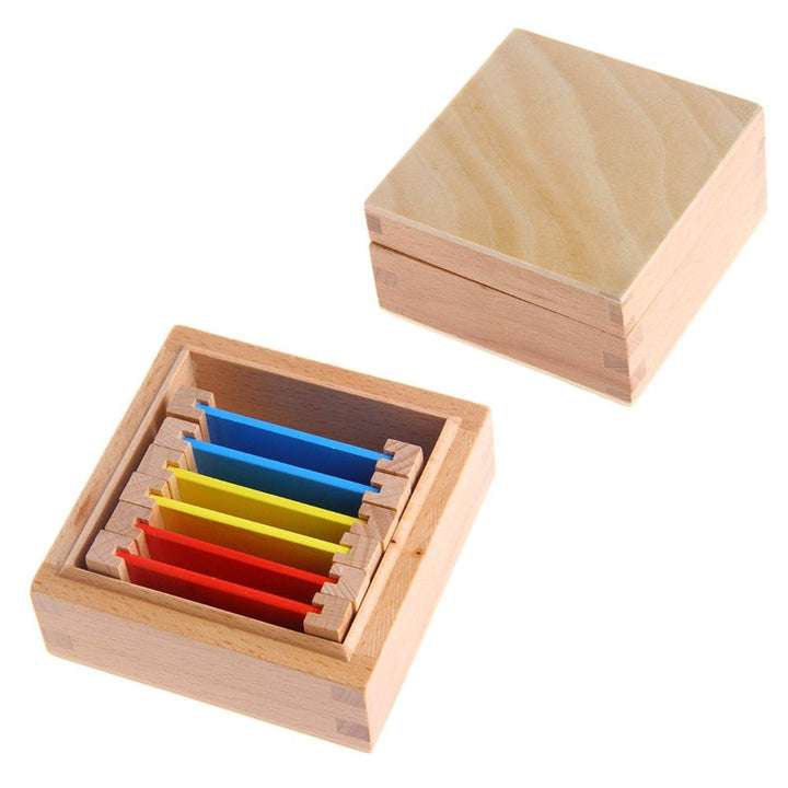 Tablettes de couleurs rouges, jaunes et bleues dans boîte en bois Montessori