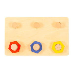Enfant de 3 ans concentré sur l'activité de vissage sur la planche SmartBebe
